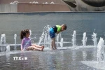Trẻ em giải nhiệt tránh nóng tại một đài phun nước. (Ảnh: THX/TTXVN)