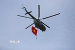 Trực thăng của Không quân Việt Nam kéo cờ Tổ quốc tung bay trên bầu trời. (Ảnh: Lê Xuân/TTXVN)