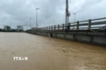 Nước lũ sông Trà Bồng đã áp sát cầu Châu Ổ. (Ảnh: TTXVN phát)