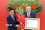 Đồng chí Trần Cẩm Tú, Ủy viên Bộ Chính trị, Thường trực Ban Bí thư trao Huy hiệu Đảng và tặng hoa chúc mừng Tổng Bí thư Tô Lâm. (Ảnh: Thống Nhất/TTXVN)