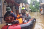 Công an thành phố Huế hỗ trợ, di dời người dân phường An Cựu ra khỏi vùng ngập lụt. (Ảnh: TTXVN phát)