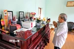 Thân nhân nhà báo, liệt sỹ Nguyễn Hữu Bản (sinh năm 1921 tại thôn Đại Lai, xã Phú Xuân, thị xã Thái Bình nay là phường Trần Hưng Đạo, tỉnh Hưng Yên) dâng hương trước ban thờ ông. (Ảnh: Thế Duyệt/TTXVN)