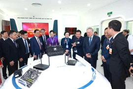 Phó Thủ tướng Thường trực Nguyễn Hòa Bình và các đại biểu tham quan khu trưng bày sản phẩm dịch vụ của VNPT. (Ảnh: P.V/Vietnam+)