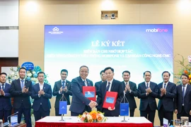 Chủ tịc MobiFone và Chủ tich CMC ký và trao biên bản ghi nhớ hợp tác. (Ảnh: PV/Vietnam+)