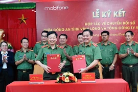 Thiếu tướng Trương Sơn Lâm - Chủ tịch MobiFone và Thiếu tướng Nguyễn Thanh Hải - Giám đốc Công an tỉnh Vĩnh Long trao văn bản hợp tác. (Ảnh: PV/Vietnam+)