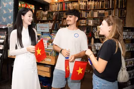 Du khách Mỹ được tặng cờ đỏ sao vàng khi du lịch Thành phố Hồ Chí Minh cuối tháng Tư vừa qua. (Ảnh minh họa: CTV/Vietnam+)