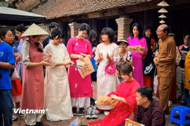 Du khách Hàn Quốc trải nghiệm với di sản tranh dân gian Đông Hồ của Việt Nam. (Ảnh: Mai Mai/Vietnam+)