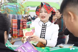 Hoàng Thị Bích với bộ trang phục truyền thống của người Thái trắng ở Mộc Châu, giới thiệu sản phẩm tại tại Hội chợ mùa Thu 2025. (Ảnh: Phi Tuấn/Vietnam+)