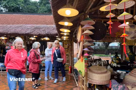Du khách quốc tế tham quan không gian trưng bày sản phẩm làng nghề truyền thống ở Văn Miếu-Quốc Tử Giám. (Ảnh: Mai Mai/Vietnam+)