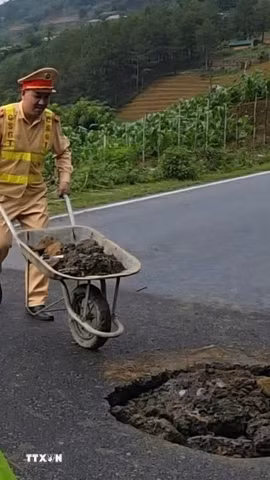 Lực lượng chức năng tiến hành lấp các hố sụt, đặt biển cảnh báo để đảm bảo an toàn. (Ảnh: TTXVN phát)