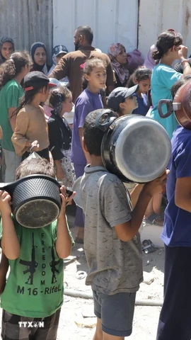 Trẻ em xếp hàng nhận thức ăn cứu trợ tại trại tị nạn Jabalia ở Dải Gaza. (Ảnh: THX/TTXVN)