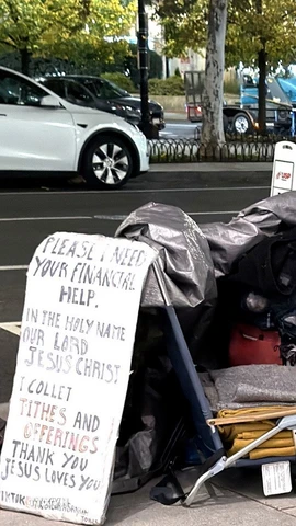 Một người vô gia cư với tấm biển cần giúp đỡ về tài chính trên một tuyến phố ở trung tâm thủ đô Washington D.C. (Ảnh: Ngọc Quang/TTXVN)