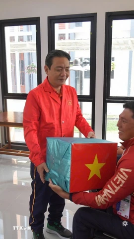 Thứ trưởng Hoàng Đạo Cương trao tặng quà và gửi lời chúc thi đấu thành công tới các đội tuyển của đoàn Thể thao người khuyết tật Việt Nam. (Ảnh: TTXVN phát)