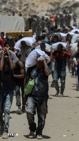 Người dân Palestine nhận hàng viện trợ nhân đạo tại Beit Lahia, phía Bắc Dải Gaza, ngày 1/8/2025. (Ảnh: THX/TTXVN)