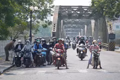 Người dân thành phố Huế mặc đồ bảo hộ chống nắng khi, di chuyển ở phía Bắc cầu Trường Tiền, phường Phú Xuân. (Ảnh: Nguyên Lý/TTXVN)