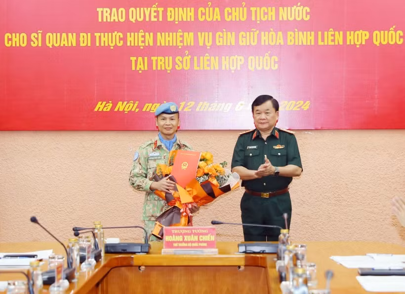 Thượng tướng Hoàng Xuân Chiến, Thứ trưởng Bộ Quốc phòng, Tổ trưởng Tổ Công tác liên ngành, Trưởng ban Chỉ đạo Bộ Quốc phòng trao Quyết định của Chủ tịch nước cho Thượng tá Trương Anh Tuấn, sỹ quan quân vụ của Cục Gìn giữ hòa bình trước khi lên đường làm nhiệm vụ tại Liên Hợp quốc. (Ảnh: Trọng Đức/TTXVN)