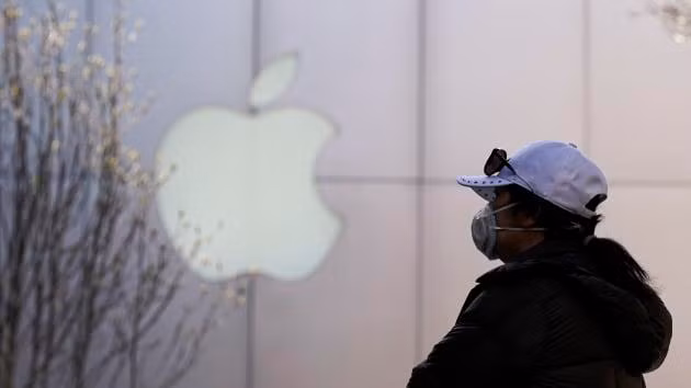 Một người dân đeo khẩu trang bên ngoài cửa hàng Apple ở Bắc Kinh, tháng 3/2020. (Nguồn: Getty Images)