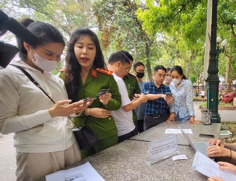 Cán bộ công an hướng dẫn người dân thực hiện cấp Phiếu Lý lịch tư pháp trên VNeID. (Ảnh: Kim Anh/TTXVN)