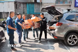 Anh Lỗ Minh Tuấn, Đội trưởng “Đội xe 0 đồng Hà Nội” cùng Tình nguyện viên tiếp nhận hàng hỗ trợ do các tổ chức, cá nhân quyên góp. (Ảnh: Lê Đông/TTXVN)