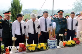 Phó Chủ tịch Thường trực Quốc hội Đỗ Văn Chiến (thứ 3, trái sang) cùng các đồng chí lãnh đạo dành phút mặc niệm bên phần mộ 93 hài cốt liệt sỹ được an táng, tưởng nhớ và tri ân các anh hùng liệt sỹ đã hy sinh vì Tổ quốc. (Ảnh: Đức Thọ/TTXVN)