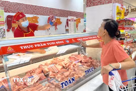 Người dân mua thịt lợn tài quầy Vissan trong siêu thị Co.opmart Lý Thường Kiệt, TP. Hồ Chí Minh. (Ảnh: Hương Giang/TTXVN)