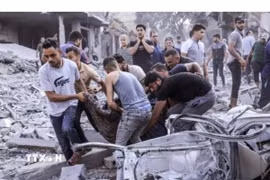 Chuyển thi thể người Palestine thiệt mạng sau các cuộc không kích của Israel xuống Dải Gaza. (Ảnh: IRNA/TTXVN phát)