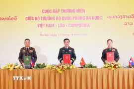 Phó Thủ tướng, Bộ trưởng Bộ Quốc phòng ba nước ký Biên bản cuộc gặp. (Ảnh: Trọng Đức/TTXVN)