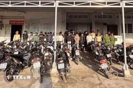 Nhóm thanh, thiếu niên tụ tập "đi bão" lúc rạng sáng cùng phương tiện được đưa về trụ sở Công an. (Ảnh: TTXVN phát)