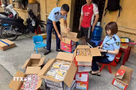 Lực lượng chức năng thu giữ bánh trung thu không rõ nguồn gốc xuất xứ. (Ảnh: TTXVN phát)