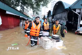 Cán bộ chiến sỹ lực lượng vũ trang tỉnh Lạng Sơn hỗ trợ tiểu thương di chuyển tài sản ra khỏi khu vực ngập sâu. (Ảnh: Văn Đạt/TTXVN)