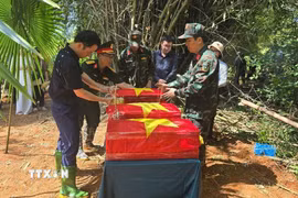 Lãnh đạo tỉnh Lào Cai, phường Cam Đường và lực lượng chức năng thực hiện các nghi thức một cách cẩn trọng, thể hiện lòng thành kính, sự tri ân sâu sắc đối với các Anh hùng liệt sỹ đã hy sinh vì Tổ quốc. (Ảnh: Hương Thu/TTXVN)