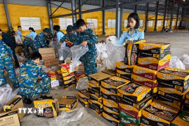 Hàng hóa, lương thực, thực phẩm, nhu yếu phẩm được vận chuyển, sắp xếp lên máy bay chuẩn bị hỗ trợ nhân dân vùng lũ. (Ảnh: Trần Lê Lâm/TTXVN)