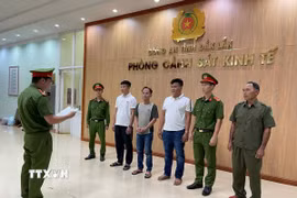 Đọc quyết định khởi tố các đối tượng sản xuất, buôn bán phân bón giả. (Ảnh: TTXVN phát)