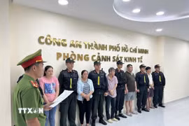 Công an đọc lệnh bắt các đối tượng. (Ảnh TTXVN phát)