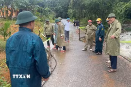 Lãnh đạo xã miền núi Linh Sơn và lực lượng chức năng khắc phục sự cố sạt lở trên tuyến đường trong xã. (Ảnh: Nguyễn Nam/TTXVN)