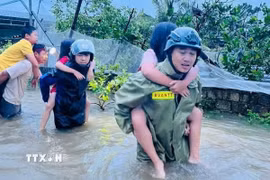 Lực lượng công an Thanh Hóa giải cứu người dân ra khỏi khu vực ngập lụt đến nơi an toàn. (Ảnh: TTXVN phát)