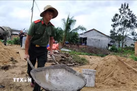 Chiến sỹ công an hỗ trợ người dân xây dựng, sửa nhà sau bão lũ nỗ lực sớm hoàn thành những căn nhà mới trong “Chiến dịch Quang Trung”. (Ảnh: Tường Quân/TTXVN)
