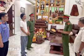 Lực lượng chức năng đọc lệnh khởi tố vụ án, khởi tố bị can. (Ảnh: TTXVN phát)