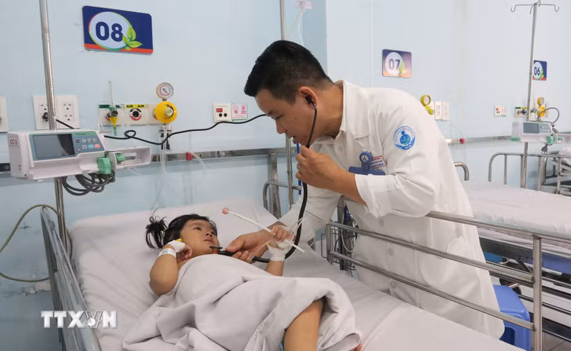 Bác sỹ Bệnh viện Nhi đồng 1 Thành phố Hồ Chí Minh, khám cho bệnh nhi mắc tay chân miệng. (Ảnh: Đinh Hằng/TTXVN)