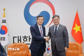 Đồng chí Đoàn Minh Huấn chụp ảnh cùng Bộ trưởng Bộ Hành chính và An toàn Hàn Quốc Yoon Ho Jung. (Ảnh: Khánh Vân/TTXVN)