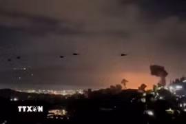 Trực thăng bay qua khu vực khói bốc lên từ loạt vụ nổ ở thủ đô Caracas, Venezuela, ngày 3/1/2026. (Nguồn: Reuters/TTXVN)
