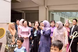 Phu nhân Nguyễn Thị Thanh Nga (áo dài, hàng trước) nghe giới thiệu về Trung tâm. (Nguồn: TTXVN phát)