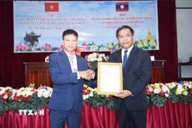 Thiếu tướng Buaphanin Thapanya, Phó Bí thư Tỉnh ủy tỉnh Xaysomboun trao quyết định thành lập Ban quản lý người Việt Nam tại tỉnh Xaysomboun cho ông Hoàng Ngọc Tuyền (trái), Trưởng ban. (Ảnh: Đỗ Bá Thành/TTXVN)