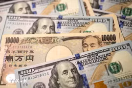 Đồng tiền mệnh giá 10.000 yen Nhật Bản và đồng 100 USD. (Ảnh: THX/TTXVN)