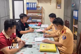 Hai tài xế xe khách làm việc với cảnh sát giao thông (Công an tỉnh Tuyên Quang). (Ảnh: TTXVN phát)
