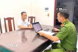 Cơ quan chức năng lấy lời khai 1 trong 6 đối tượng bị bắt về hành vi "Mua bán người” và “Mua bán trẻ em." (Ảnh: TTXVN phát)