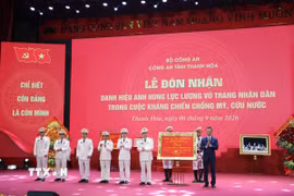 Chủ tịch Ủy ban Nhân dân tỉnh Thanh Hóa Tô Anh Dũng tặng bức trướng chúc mừng Công an tỉnh Thanh Hóa đón nhận Danh hiệu Anh hùng Lực lượng Vũ trang Nhân dân thời kỳ kháng chiến chống Mỹ, cứu nước. (Ảnh Nguyễn Nam/TTXVN)