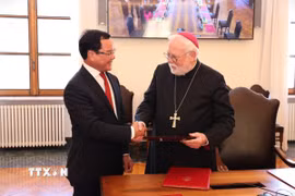 Bộ trưởng Nguyễn Đình Khang tặng quà Bộ trưởng Bộ Ngoại giao Tòa thánh Vatican - Tổng Giám mục Paul Richard Gallagher. (Ảnh: Hải Linh/TTXVN)