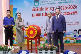 Hiệu trưởng Trường song ngữ Lào-Việt Nam Nguyễn Du Nguyễn Thị Thanh Hương đánh trống khai giảng năm học mới 2025-2026. (Ảnh: Xuân Tú/TTXVN)