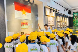 Hướng dẫn viên bảo tàng thuyết minh thông tin lịch sử cho học sinh. (Ảnh: K GỬIH/TTXVN)